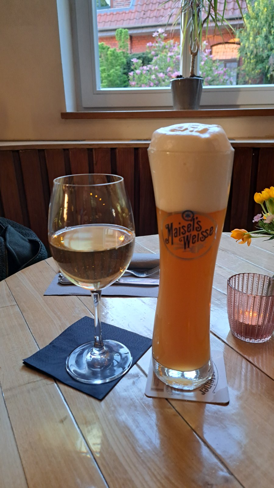 Glas Weißwein und Weizenbier am Fenster der Gaststätte Franz