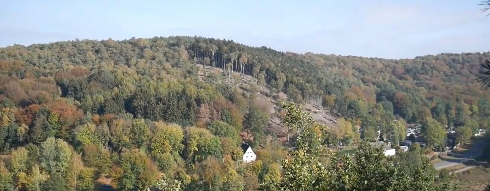 Herbstliches Panorama über den bewaldeten Höhenzug mit Dorf bei den Dörenther Klippen